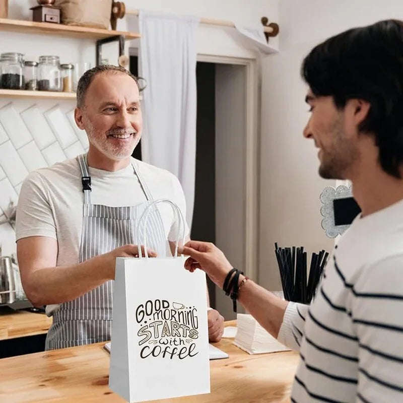 White Paper Bags with handles, 5x3x8 inches, featuring a printed design and used for coffee takeaway in a cafe setting