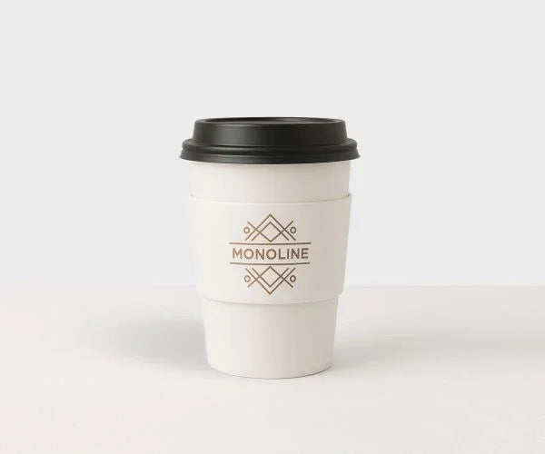 Custom Printed Coffee Cup Sleeves | Eco-Friendly Brand Packaging Canada on white cup with minimalist logo and black lid
