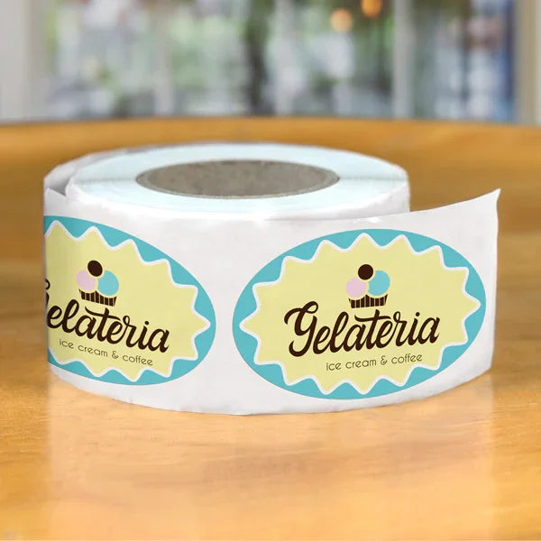 Roll of Oval Labels featuring pastel blue and yellow design with ice cream branding on wooden surface background