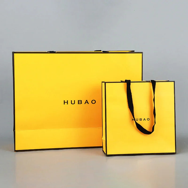 Custom Printed Laminated Paper Bags — Premium Retail Shopping Bags Wholesale in bright yellow with black handles and minimal logo print design