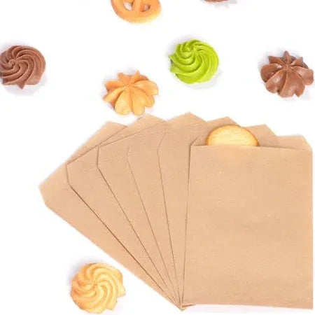 Flat Kraft Bags or Notion Kraft Paper Bags | Wholesale Eco Packaging showing small kraft paper bags with cookies and colorful frostings nearby