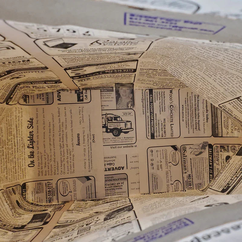 Inside view of a recycled paper bag with newspaper print, eco-friendly packaging by Greenii Inc.
