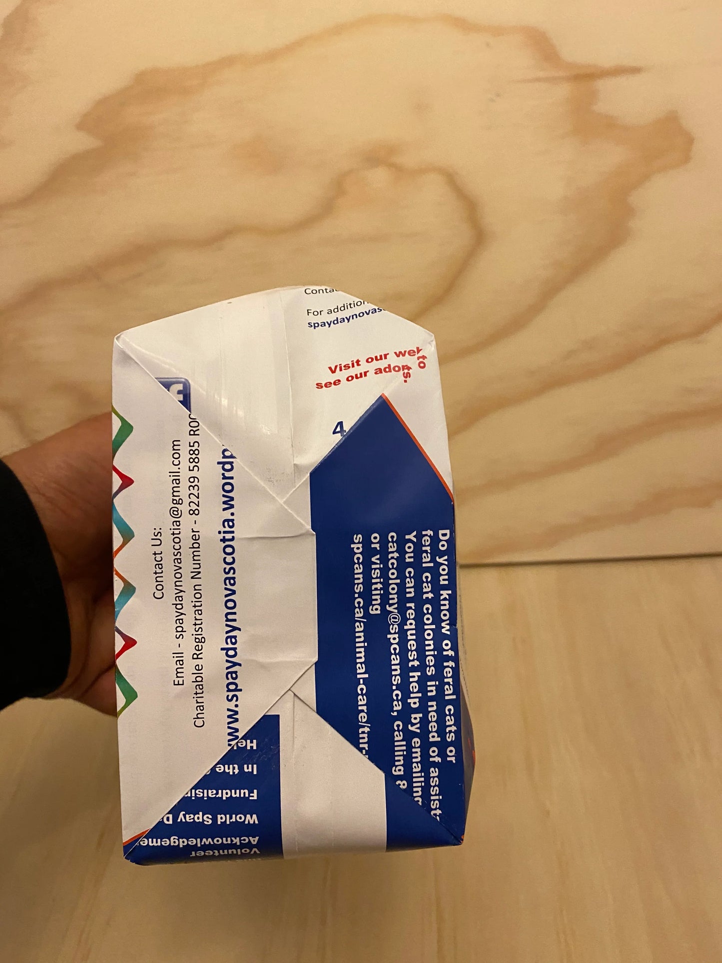 Custom paper bags crafted from repurposed printed flyers with folded construction held against wooden background