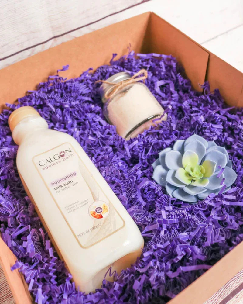 Eco-friendly gift box with Calgon milk bath, bath salt jar, and faux succulent on purple shredded paper