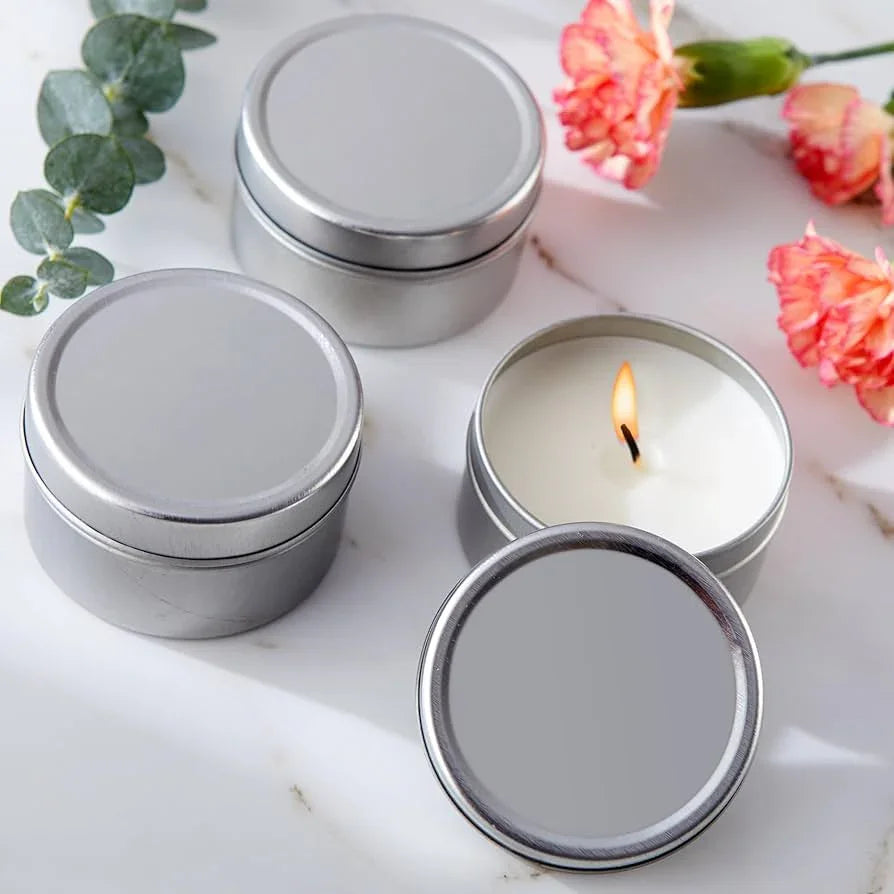 Empty Candle Jars | Wholesale Glass Containers | Eco Friendly Candle Packaging with silver metal tins and a lit candle on marble surface